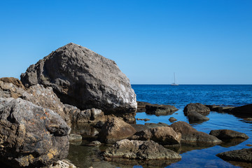 Fototapeta na wymiar Large rocks in the sea. Beautiful sea shore with large stones in the sea.