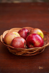 Apples in a basket on a wooden table
