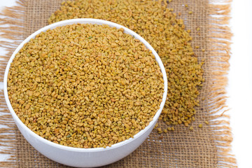 Dried fenugreek seeds isolated on white background