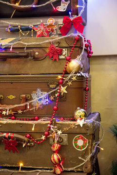 pyramid of old suitcases decorated with festoons and New Year's toys