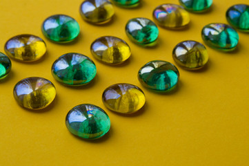 colorful glass marbles on yellow background
