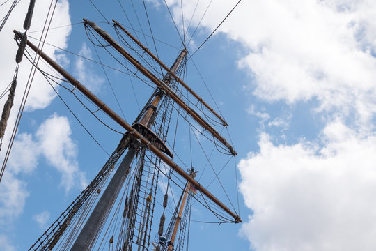 mast and rigging of an historic  sailing ship against the blue sky with clouds, adventure voyage concept, copy space