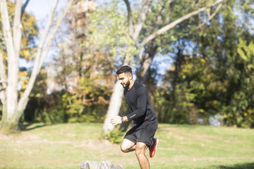 Junger sportlicher Mann joggt im Grünen