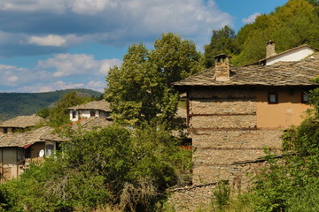 Fototapeta na wymiar Stone house with stone fence in the Village of Leshten. Historical, facade. The Village of Leshten is architectural reservation