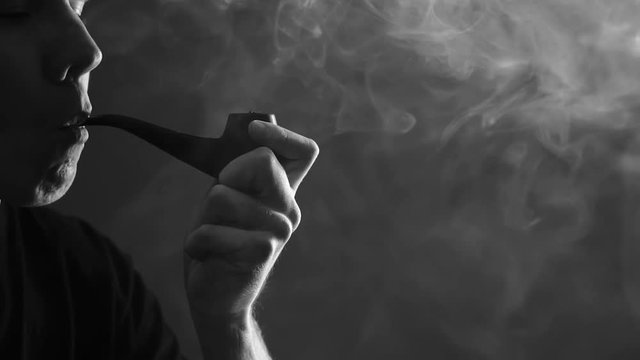 man lights Smoking pipe