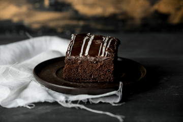 sweet chocolate brownie with coffe cream on a dark, rustic, wooden table