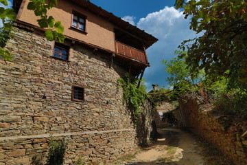 Stone house with stone fence in the Village of Leshten. Historical, facade. The Village of Leshten is architectural reservation