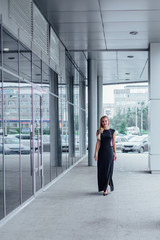 Attractive lady in long evening dress on the street