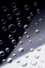 close-up view of transparent water drops on black, grey and white background