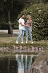 Naklejka na ściany i meble loving couple standing near a lake in a city Park