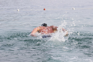 Swimmer dives into the depths of the sea. Background