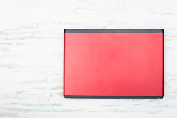  Red laptop computer isolated on white wooden background