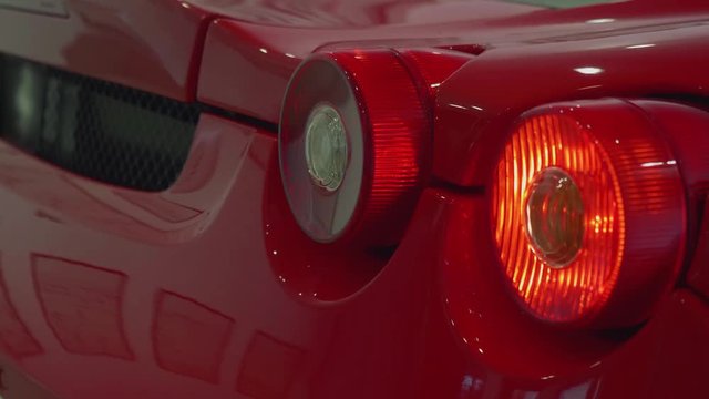 Turning signals of red sport car blink. Close up view