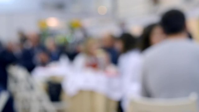 People sit in a restaurant Blurred Background. White and gray black colors