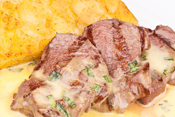 Beef tenderloin with potato pie on white plate. Close up