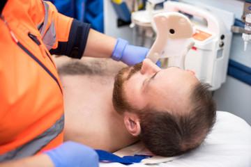 Obraz premium Emergency doctor putting a cervical collar to a patient in the ambulance
