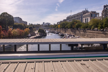 Fototapeta premium Boats parked in a port in front of buildings in Paris on the banks of the Seine in autumn