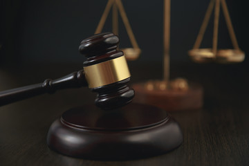 Judge gavel, scales of justice and law books in court