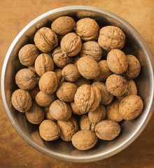 walnuts in a bowl on wooden table
