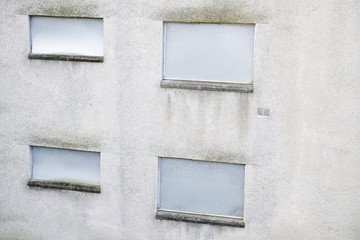 Abandoned building metal sheet board over windows dull grey dirty wall