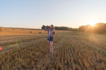 young beautiful girl with camera summer evening