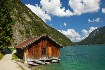 Holzhütte am Tiroler Achensee umgeben von Berglandschaft