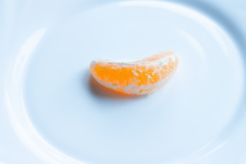 Tangerine wedge peeled on a white plate