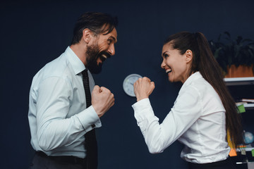 Young business people made fists and looking at each other. Fight of genders concept.