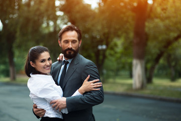 Modern two young business people stand outside. Hugging each other. Business unity concept.