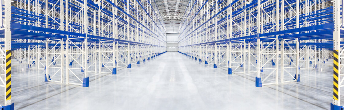 Passageway in an empty huge distribution warehouse with high shelves