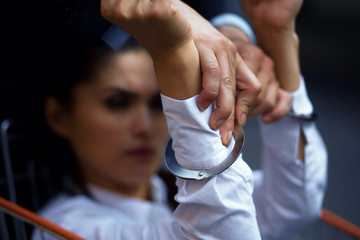 Angry businesswoman having handcuffs on hands. Man holding her hands. Fight of gender comcept.