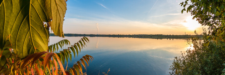 Colorful leaves in front of a blue lake, beautiful background panorama