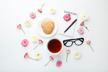 Rose flowers with cup of tea and cookies on white background
