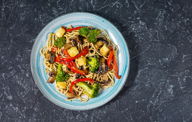 Asian tofu soba noodle bowl on stone background.