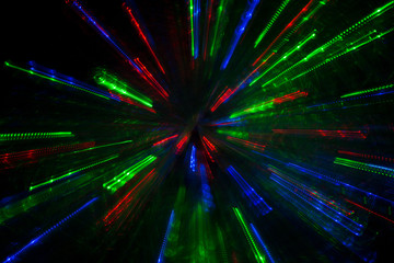 Obraz premium multicolored rays flying to the sides on a black background, beautiful fireworks, lighting effects, abstract concept