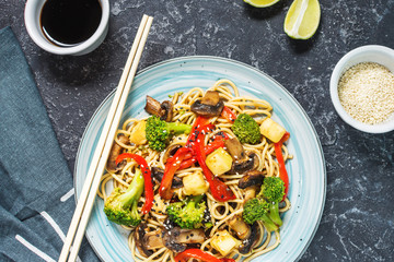 Asian tofu soba noodle bowl on stone background.