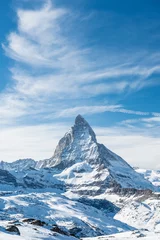 Crédence en verre imprimé Cervin Vue panoramique sur le pic enneigé du Cervin en journée ensoleillée avec ciel bleu et nuages spectaculaires en arrière-plan, Suisse