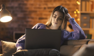 Woman relaxing and watching movies on her laptop