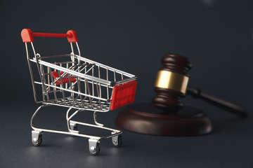 Close-up Of Brown Gavel And Shopping Cart In Front Of Law