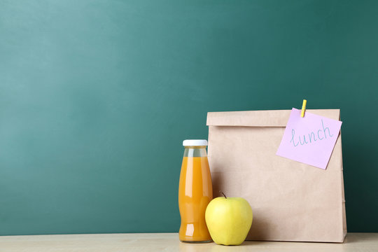 School lunch in paper bag on chalkboard background