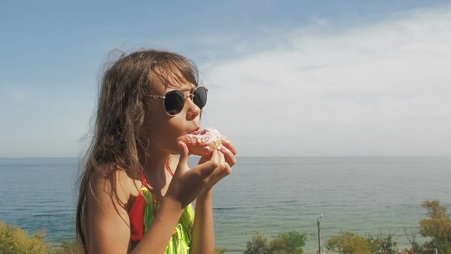 Child with donut. The little girl is eating a donut.