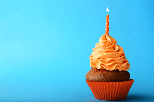 Tasty Cupcake With Candle On Blue Background