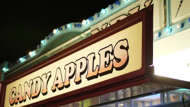 A Slow Motion Shot Of A Cany Apples Sign At The Carnival