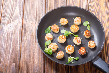 Fried scallops with lemon and salad