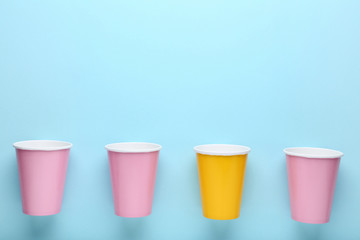 Colorful paper cups on blue background