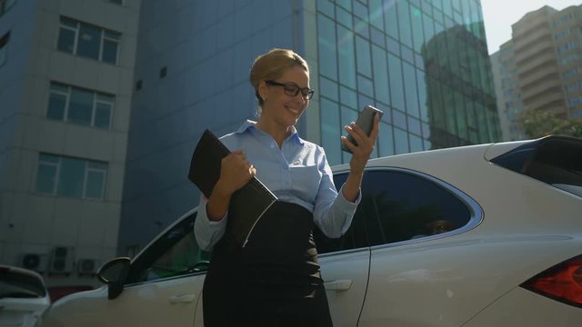 Businesslady happy with investment reads message of successful tranche on phone