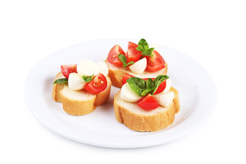 Bruschetta with mozzarella, tomatoes and basil leafs isolated on white background