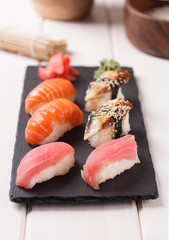 Sushi set nigiri served on black stone slate