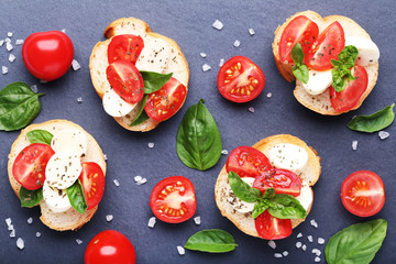 Bruschetta with mozzarella, tomatoes and basil leafs