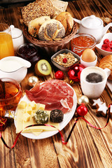 breakfast on table with bread buns, croissants, coffe and juice on christmas day. xmas holiday morning.